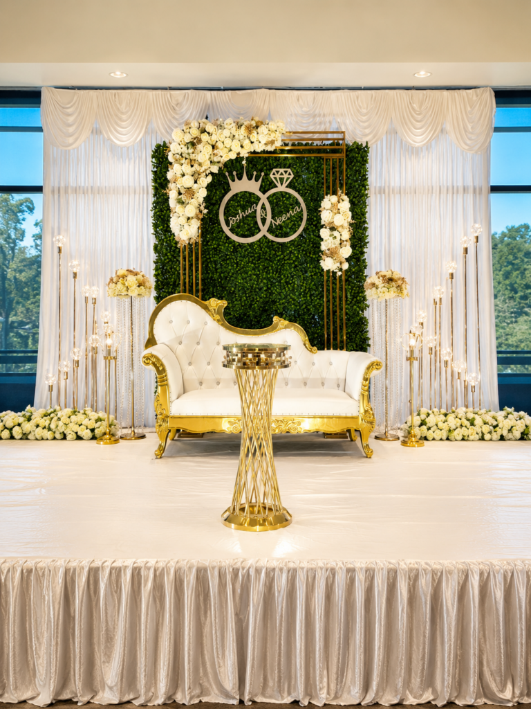 Engagement stage with greenery wall, gold seating and white florals